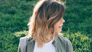 Woman in a charcoal jacket with a mid-length bob with long layers
